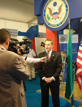 A man speaks to camera as a reporter holds a microphone.