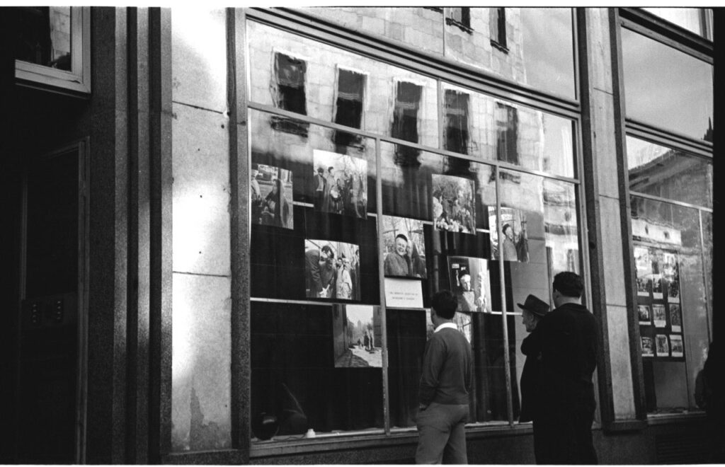 A group of people looking at photos on a window