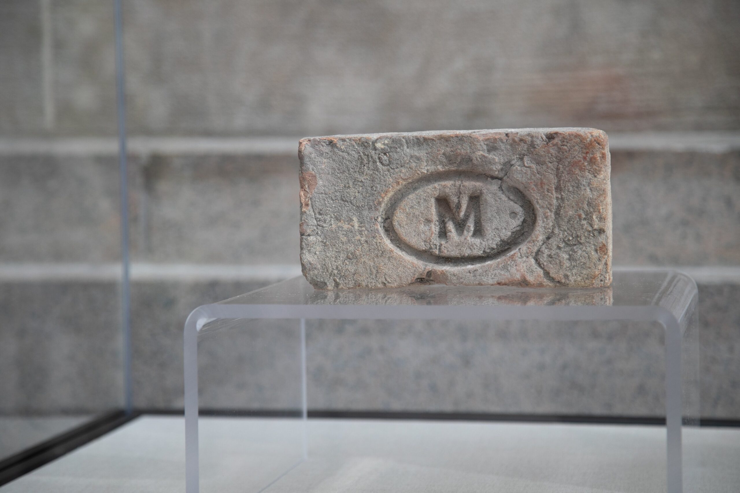 Brick with the letter M circled stamped. 