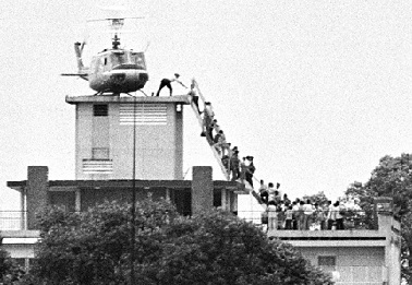 A member of the CIA helps evacuees up a ladder onto an Air America helicopter on the roof of 22 Gia Long Street