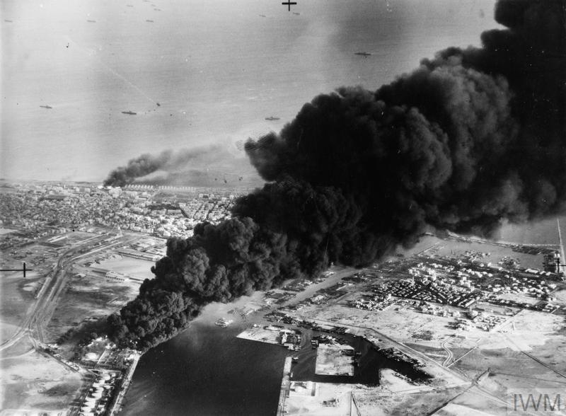  MUSKETEER) 1956 (MH 23509) Smoke rises from oil tanks beside the Suez Canal hit during the initial Anglo-French assault on Port Said, 5 November 1956. 