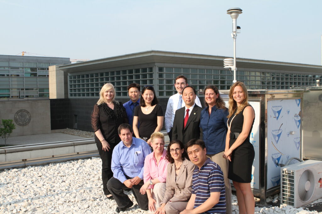 A group stands in front of an air quality monitor