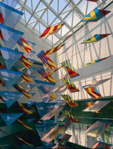 Flags flying in a large atrium with a windowed ceiling