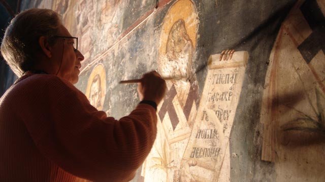 A man painting an old painting