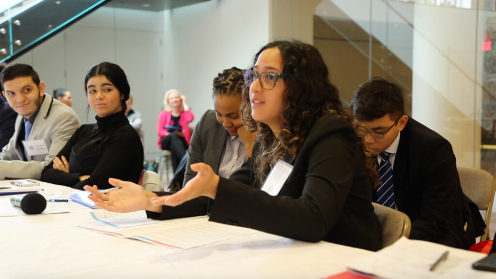 A student speaks from a conference table