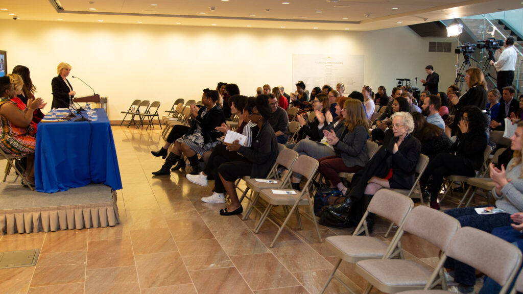 Audience clapping as Museum Director Mary Kane addresses the audience during the event. 