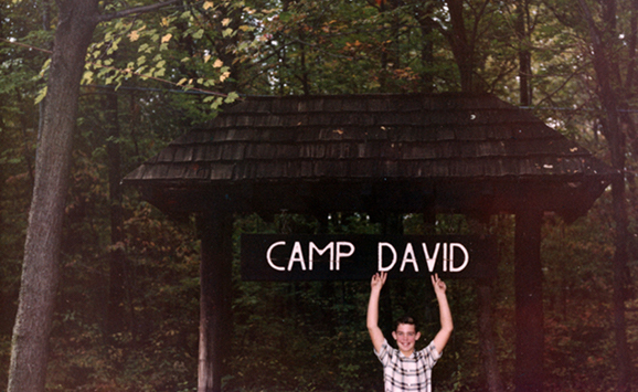 Boy points to sign above head saying Camp David