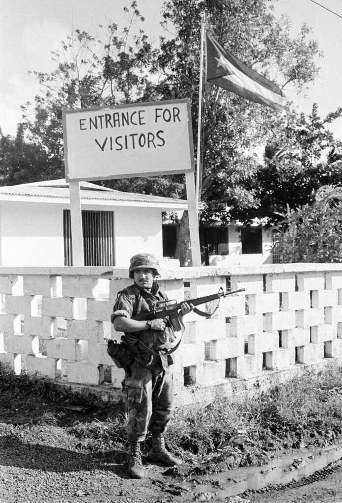 A soldier with a gun stands outside the Cuban Embassy in Grenada