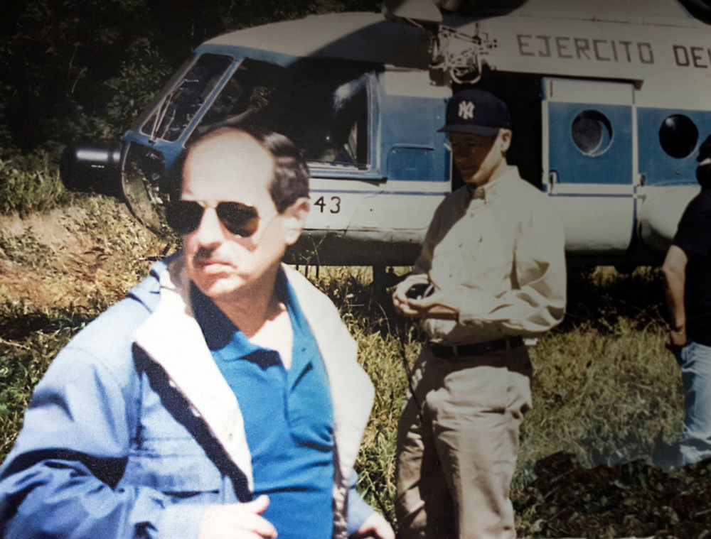 Gutierrez and Joseph Nye stand n front of a helicopter in Peru