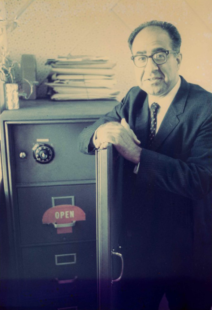 Philip Habib standing next to a safe.