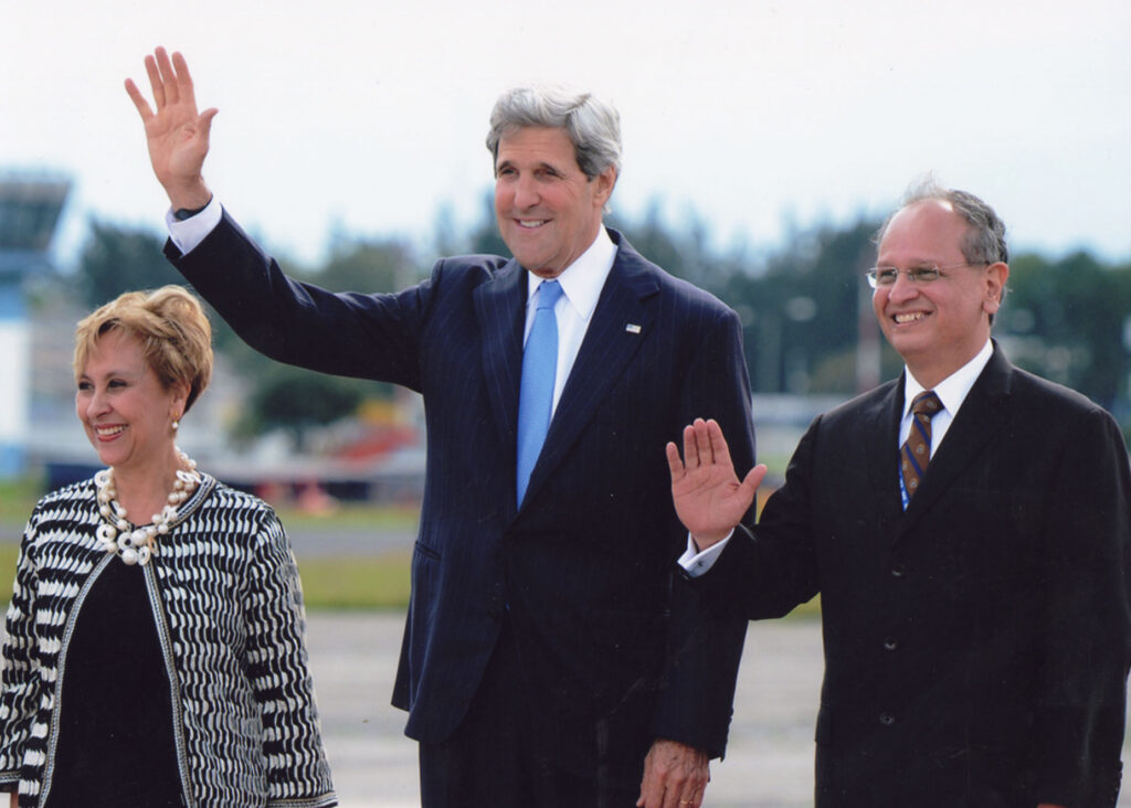 Chacon, John Kerry, and Rita Claverie wave