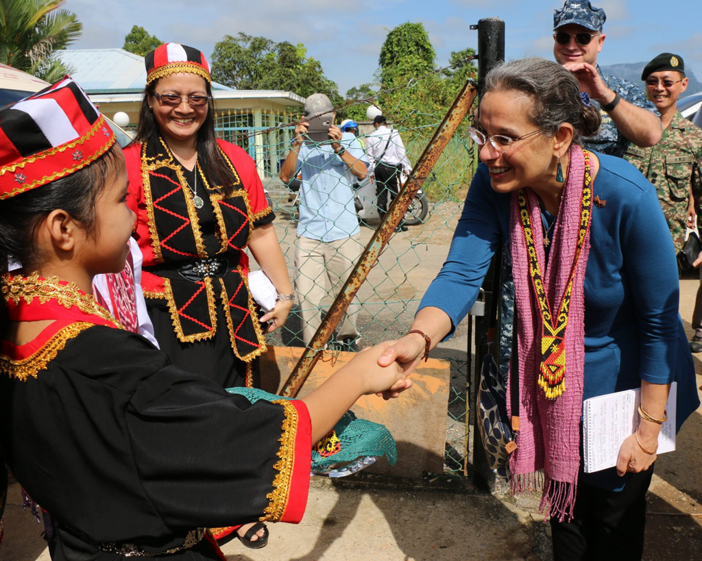 Ambassador Lakhdhir shakes the hand of a Malaysian child