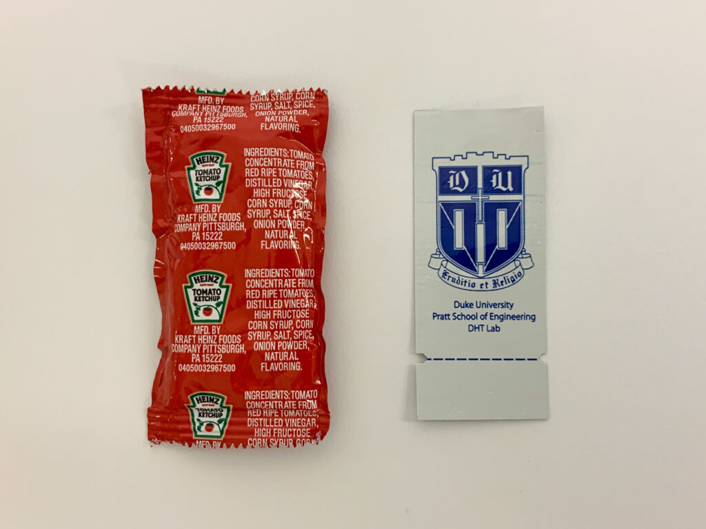 a ketchup packet next to a pratt pouch 