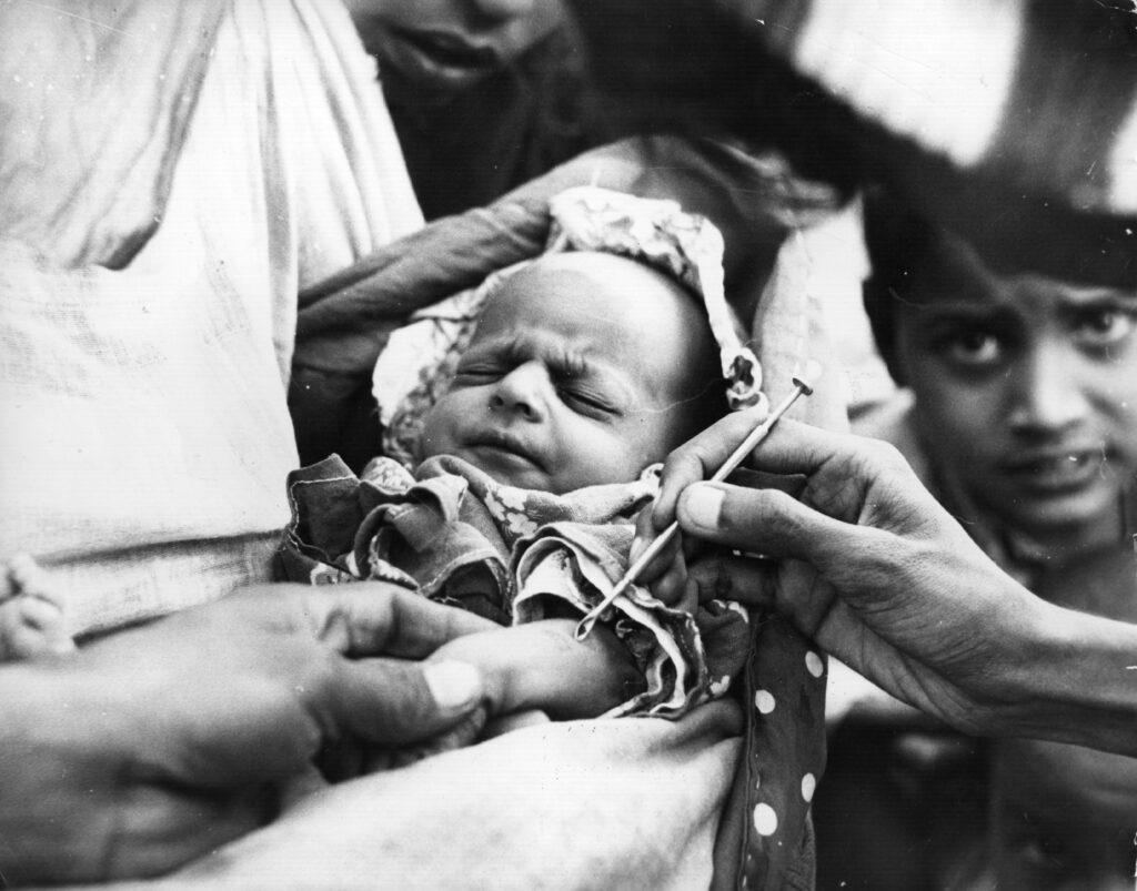 a baby in Pakistan receiving a smallpox vaccine