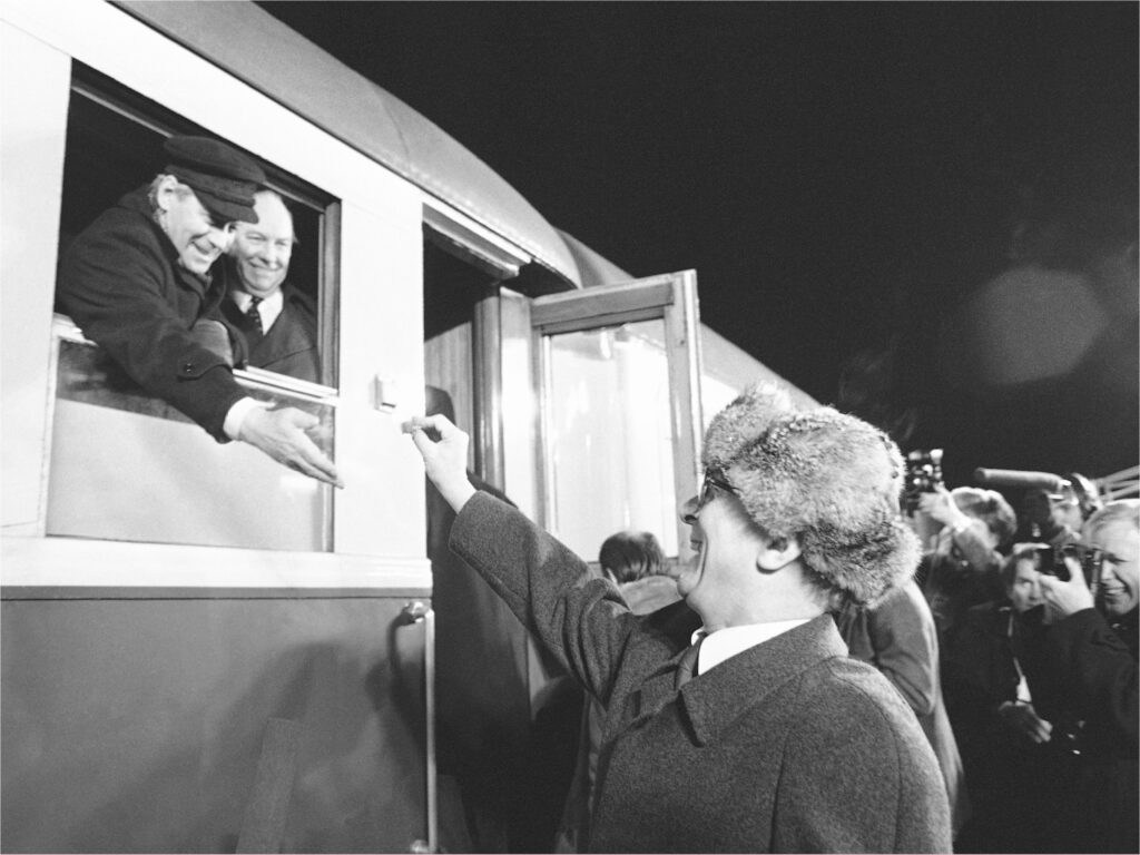 East German State and Party leader Erich Honecker offers candy as a farewell gift to West German Chancellor Helmut Schmidt as Schmidt leaves East Germany en route to West Germany in 1981. Beside Schmidt is West German Minister for German Affairs, Egon Franks. AP photo.