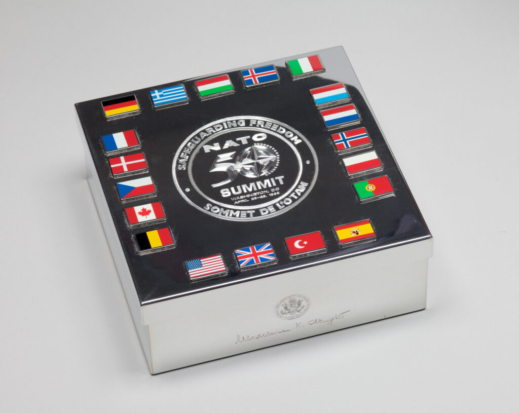 A silver box with flags of NATO countries and the NATO seal