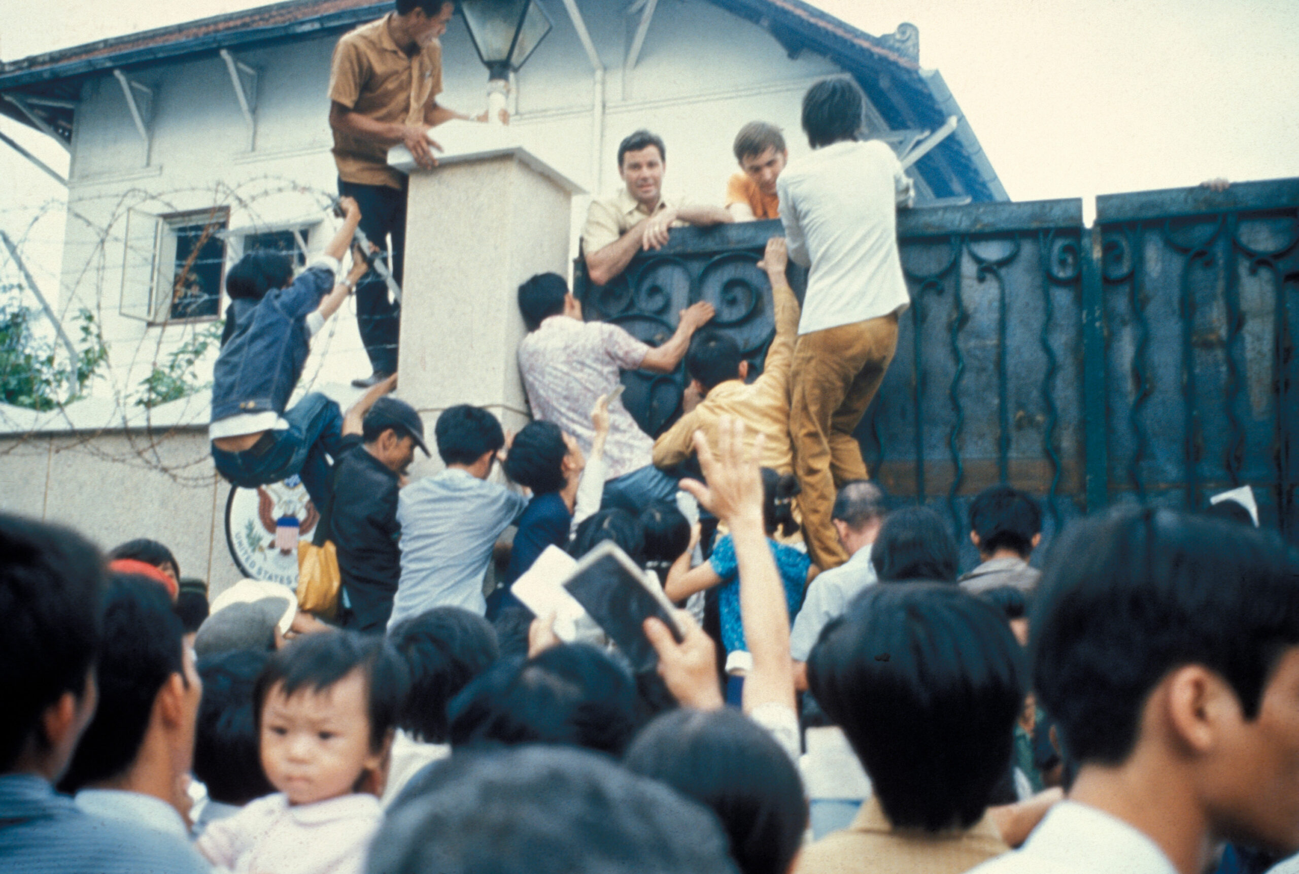People scaling a wall at the US embassy in Saigon