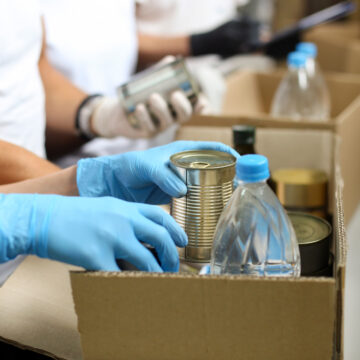 Person with gloves putting supplies in a box