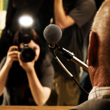 Person with a microphone talking to the press