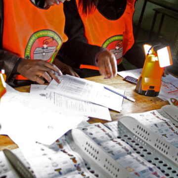 Two election workers filling out ballots