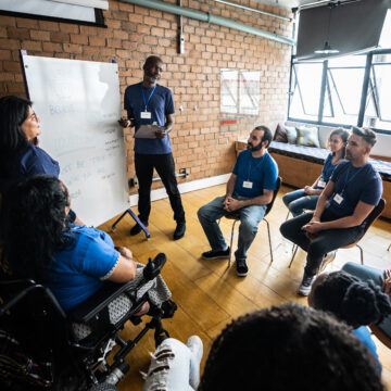 A group of people in an office sitting in a circle.