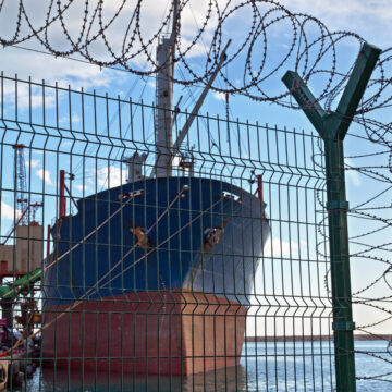 A cargo ship behind a fence