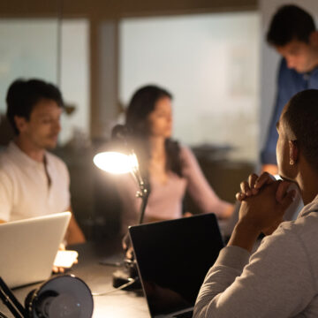 A group of people in a dimly lit office