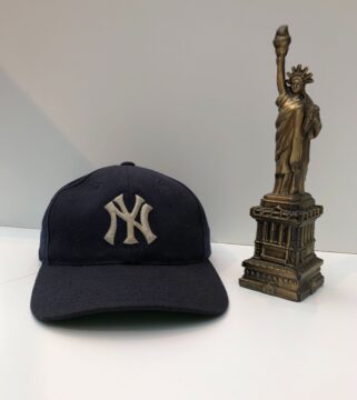 A Yankees baseball cap and a statue of liberty replica.