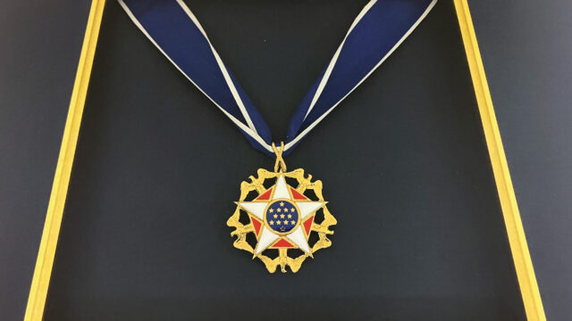 A star-shaped medal hanging on a blue ribbon.