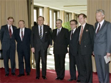 The delegation for the first Two Plus Four negotiations poses for the press in Bonn, West Germany. From right to left: Dieter Kastrup (West Germany), John Weston (Great Britain), Anatoli Leonidovich Adamachin (USSR), Bertrand Dururcq (France), Hans-Dietrich Genscher (West Germany), Ernst Krabatsch (East Germany) and Robert Zoellick (USA).