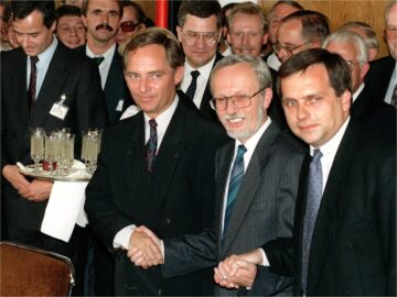 West German Secretary of State Wolfgang Schaeuble (left), his East German counterpart Guenther Krause (right) and East German Prime Minister Lothar de Maizire (center) symbolically holding hands following the signing of the German unification treaty in East Berlin.