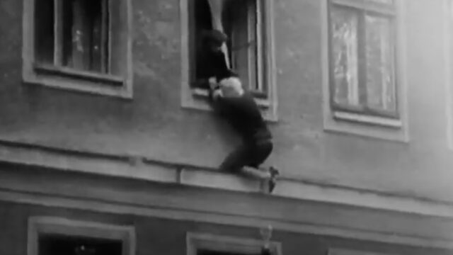 a woman hangs outside of her apartment window