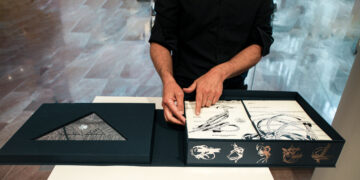 a person's hands in front of an artist book