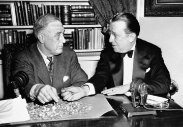 two men in front of a desk with dimes