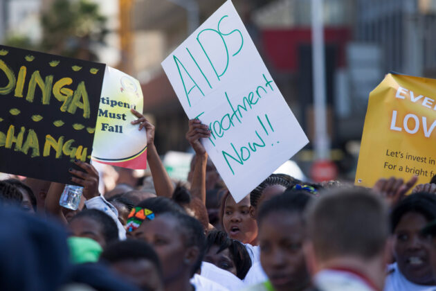 A woman holds up a sign that says 