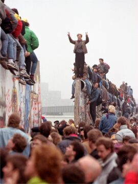 Foto: Menschen dicht gedrängt auf und an der Berliner Mauer, die ein Stück geöffnet ist