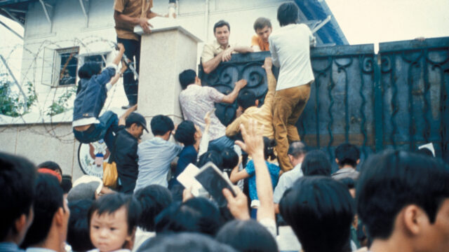 People scaling a wall at the US embassy in Saigon
