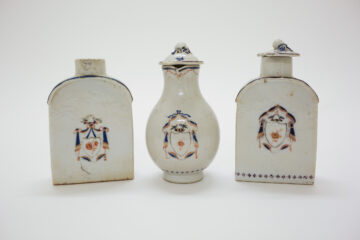 A set of white Chinese porcelain teaware with blue and gold decorations.