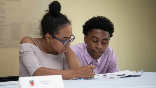 Two students sit looking at a simulation packet