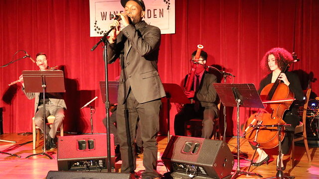 Konshens the MC performs at City Winery with musicians behind him.