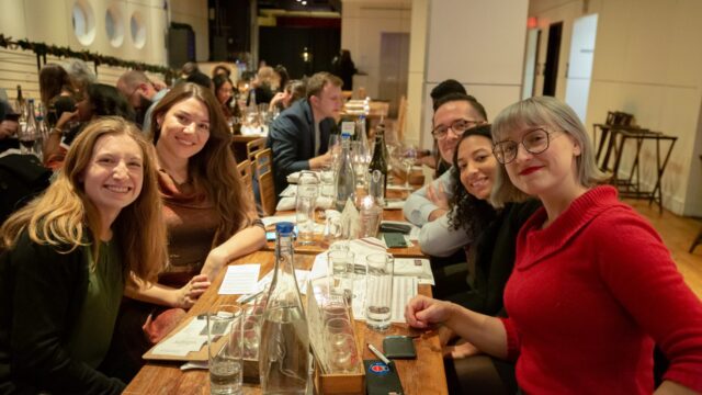 Five people at a table smiling for the camera