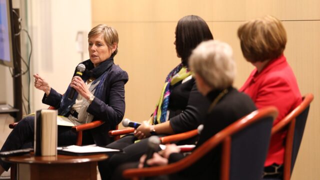 Dr. Victoria Philips speaks into microphone and fellow panelists look on