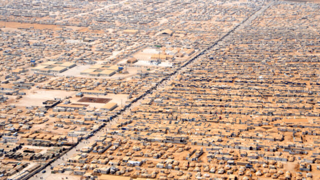 Aerial photgraph of a network of houses and tents.