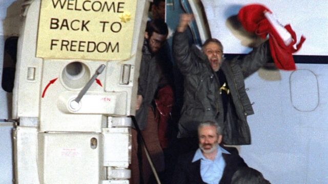 David Roeder shouts and waves as he and others exit an airplane