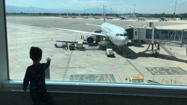 The son of Foreign Service Health Provider Luke Caldwell looks at the repatriation airplane at the Algiers International airport that will take him and his mother home to the United States.