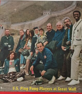 A group of ping-pong players in front of the Great Wall of China