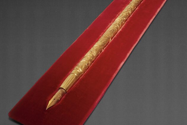 A gold pen on red felt
