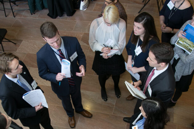 Aerial shot of a group of students in business attire participating in a diplomacy simulation