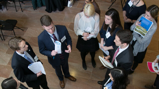 Aerial shot of a group of students in business attire participating in a diplomacy simulation